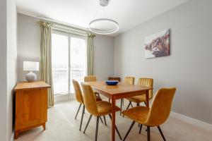 a dining room with a wooden table and chairs at The Argyle Apartment - Luxury - Parking in St Andrews