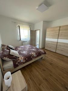 sypialnia z dużym łóżkiem i drewnianą podłogą w obiekcie Apartman Varea w mieście Ližnjan