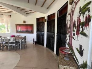 a dining room with a table and a wall with a painting at Miky House in Watamu