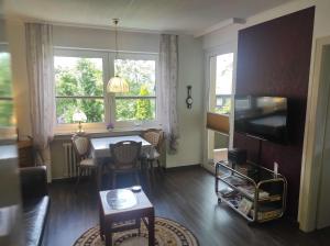 a living room with a table and a television at Ferienwohnung Schüler-Wolke 2 in Sankt Andreasberg