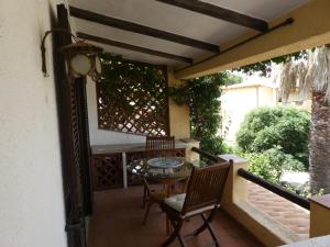 um pátio com uma mesa e cadeiras numa varanda em La Casetta Cannigione em Cannigione