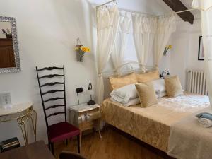 a bedroom with a bed and a chair and a window at La Casa Celeste B&B in Asti +75 photos