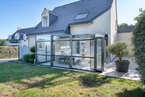 an extension to a house with glass doors and a patio at Maison avec piscine ! Pour 8 personnes a Saint-Gildas-de-Rhuys in Saint-Gildas-de-Rhuys