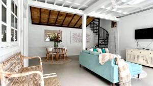 a living room with a blue couch and a table at Tiga Pantai Villa Legian in Legian