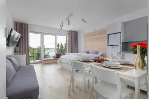 a living room with a bed and a table with chairs at Seaside Apartamenty Dominikana Sianożęty Basen&Jakuzzi&Parking in Sianozety