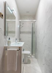 a white bathroom with a sink and a shower at Ayala apartment by People Rentals in Bilbao