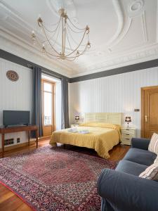 a bedroom with a bed and a couch and a tv at Ayala apartment by People Rentals in Bilbao