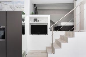 een kamer met een trap met een bed en een tv bij Nest for 2 in Milan Fashion District in Milaan