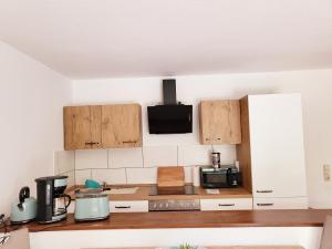 a kitchen with wooden cabinets and a microwave at Exklusivwohnung Nempitz in Nempitz