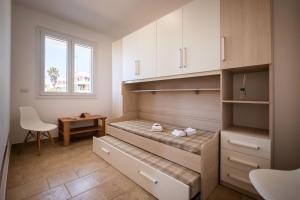 Schlafzimmer mit einem Bett, einem Schreibtisch und einem Fenster in der Unterkunft Villa Bianca in Torre Pali 