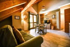 a living room with a couch and a table at Stalle Lunghe Deluxe Apartments in Prato Nevoso