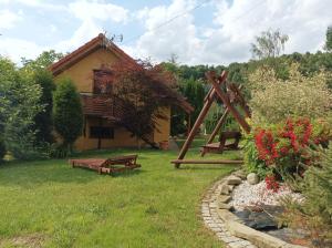 a yard with a house with a swing and a garden at Słoneczna Hytte in Brenna