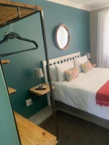 a bedroom with a white bed and a mirror at Namibia Nights Accommodation in Swakopmund