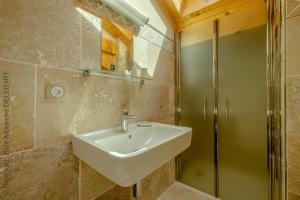 uma casa de banho com um lavatório e um chuveiro em Chalet aux 3 biches em Mieussy