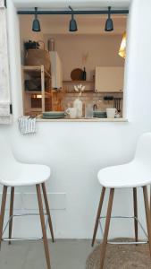 two white bar stools in front of a kitchen counter at NOMAD SURF HOUSE in Corralejo