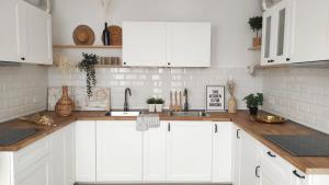 a kitchen with white cabinets and wooden counter tops at NOMAD SURF HOUSE in Corralejo