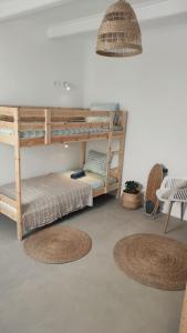 two bunk beds in a room with two rugs at NOMAD SURF HOUSE in Corralejo