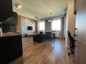 a living room with a table and chairs at Tricity Apartments - Wilga Park in Gdańsk +3 photos