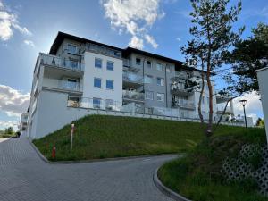 ein großes weißes Gebäude auf einem Hügel in der Unterkunft Tricity Apartments - Wilga Park in Danzig