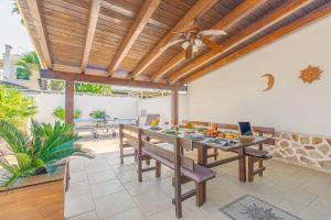 a dining room with a table and a ceiling fan at Villa Agave al mare in Specchiolla 