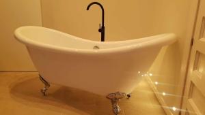 bagno con vasca bianca e luci di El silencio boutique room a Segovia