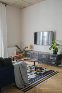 a living room with a couch and a tv on a wall at Spacious brand new modern apartment in Old Town in Rīga