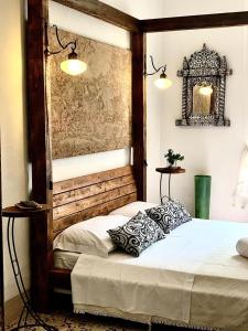 une chambre avec deux lits et un miroir au mur dans l'établissement Il Vecchio Cortile, à Agrigente