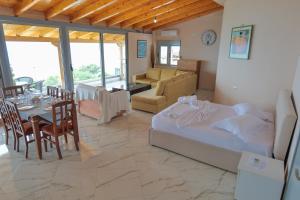 a living room with a bed and a dining room at White Hotel in Borsh
