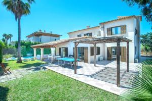 a house with a patio with a table and a picnic table at Owl Booking Villa Llenaire Gran - 3 min Walk to the Beach in Port de Pollensa