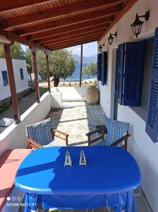 a blue table and chairs on a patio with a view of the ocean at Almyriki in Methana