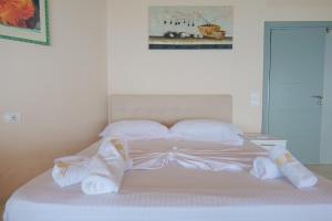 a white bed with white sheets and pillows at White Hotel in Borsh