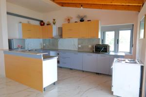 a large kitchen with stainless steel counters and cabinets at White Hotel in Borsh