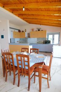 a dining room with a table and chairs and a kitchen at White Hotel in Borsh