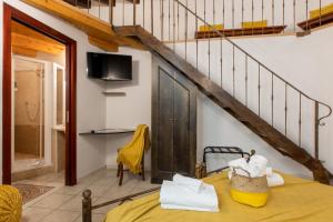 a room with a bed with a yellow blanket and a staircase at Cagliarifornia in Cagliari