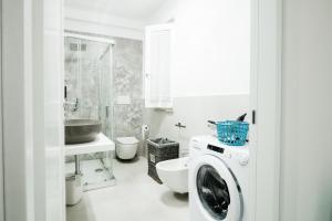 a white bathroom with a washing machine in it at Le Isole di Anita in Lipari