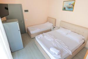 a small bedroom with two beds and a television at White Hotel in Borsh