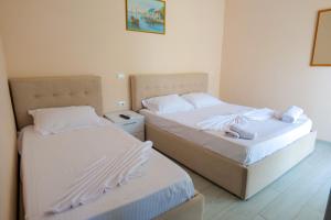 two beds sitting next to each other in a room at White Hotel in Borsh