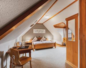 a bedroom with a bed and a desk in a attic at Fremden- und Monteurzimmer "Zum Ochsen" in Flieden