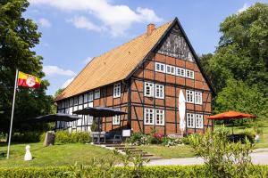 un grand bâtiment brun avec un drapeau devant lui dans l'établissement Appartementhotel Blomberger Hof, à Blomberg