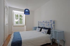 a bedroom with a bed and a blue lamp at Portas da Sé Apartments in Lisbon
