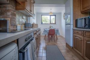 a kitchen with a counter and a table in it at Avoca - 3 Bedroom Holiday Home - Llangennith in Llangennith