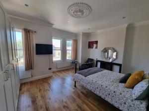 a bedroom with a bed and a flat screen tv at Tulse Hill Luxury Cosy Rooms in London