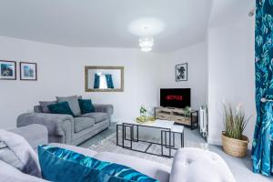 a living room with a couch and a tv at Carterson Serviced Apartment Coventry in Coventry