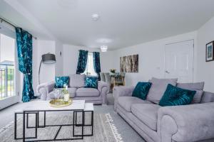 a living room with two couches and a table at Carterson Serviced Apartment Coventry in Coventry