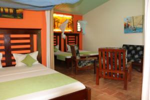 ディエゴ・スアレスにあるHotel De La Baieのベッドルーム1室(ベッド1台、テーブル、椅子付)