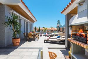 a patio with a fireplace and a table and chairs at villa leonardo in Puerto de Santiago