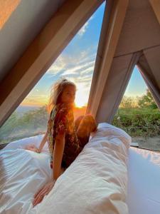 a doll sitting on a bed in front of a window at Tipì - Glamping Experience in Chiusanico