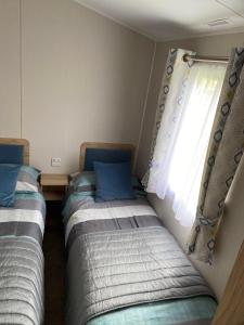 two beds sitting in a room with a window at Malton 74 in Dunoon