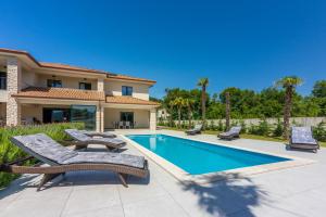 une villa avec piscine et mobilier de jardin dans l'établissement Villa Palma with Heated Private Pool, à Podhum
