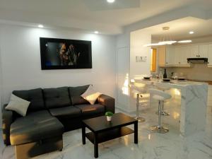 a living room with a couch and a kitchen at Balcon Atlantico Holiday Tenerife in Adeje